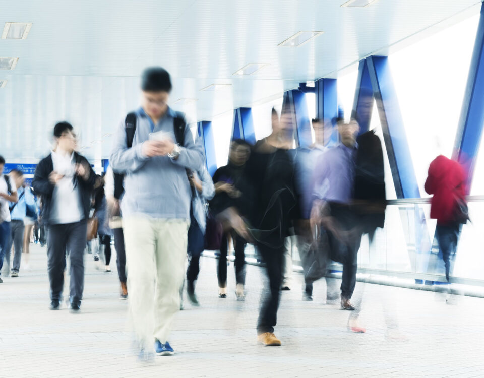 A crowd of people walking down a hallway on a stressful day.