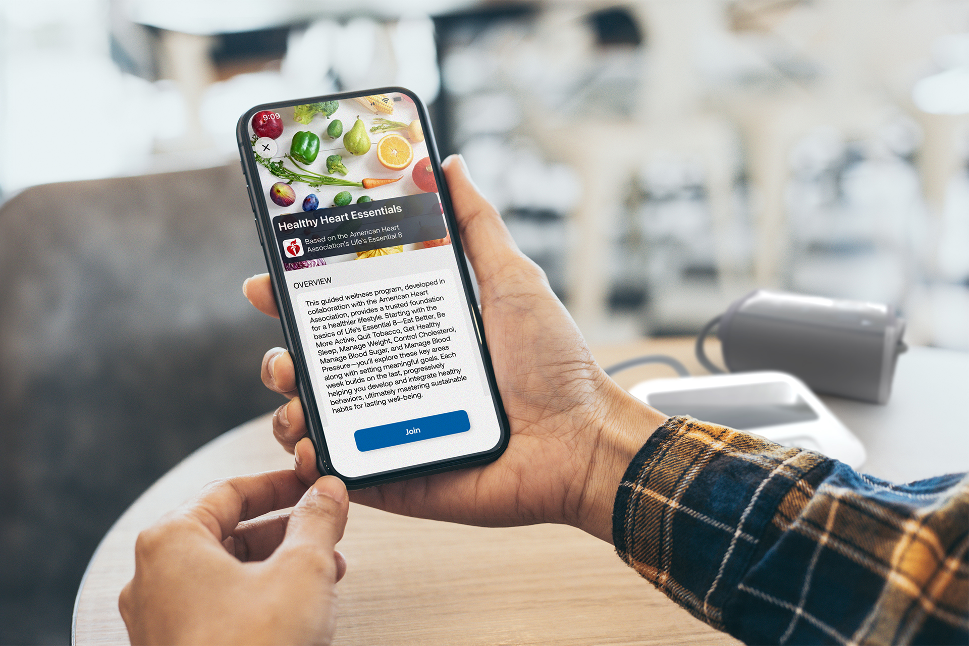User holding a phone displaying the overview screen of a Guided Wellness Program in the CONNEQT App, with an option to join.
