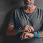 Older adult checking wearable device while monitoring arterial health