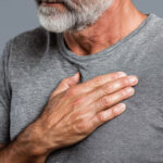 Man standing with his hand over his chest, reflecting subtle changes in cardiovascular health
